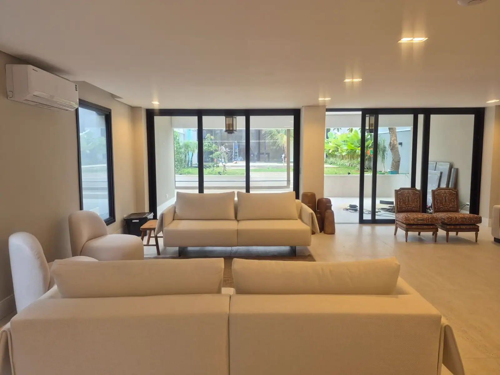 Living com portas de correr de PVC em perfil escuro e vidros amplos